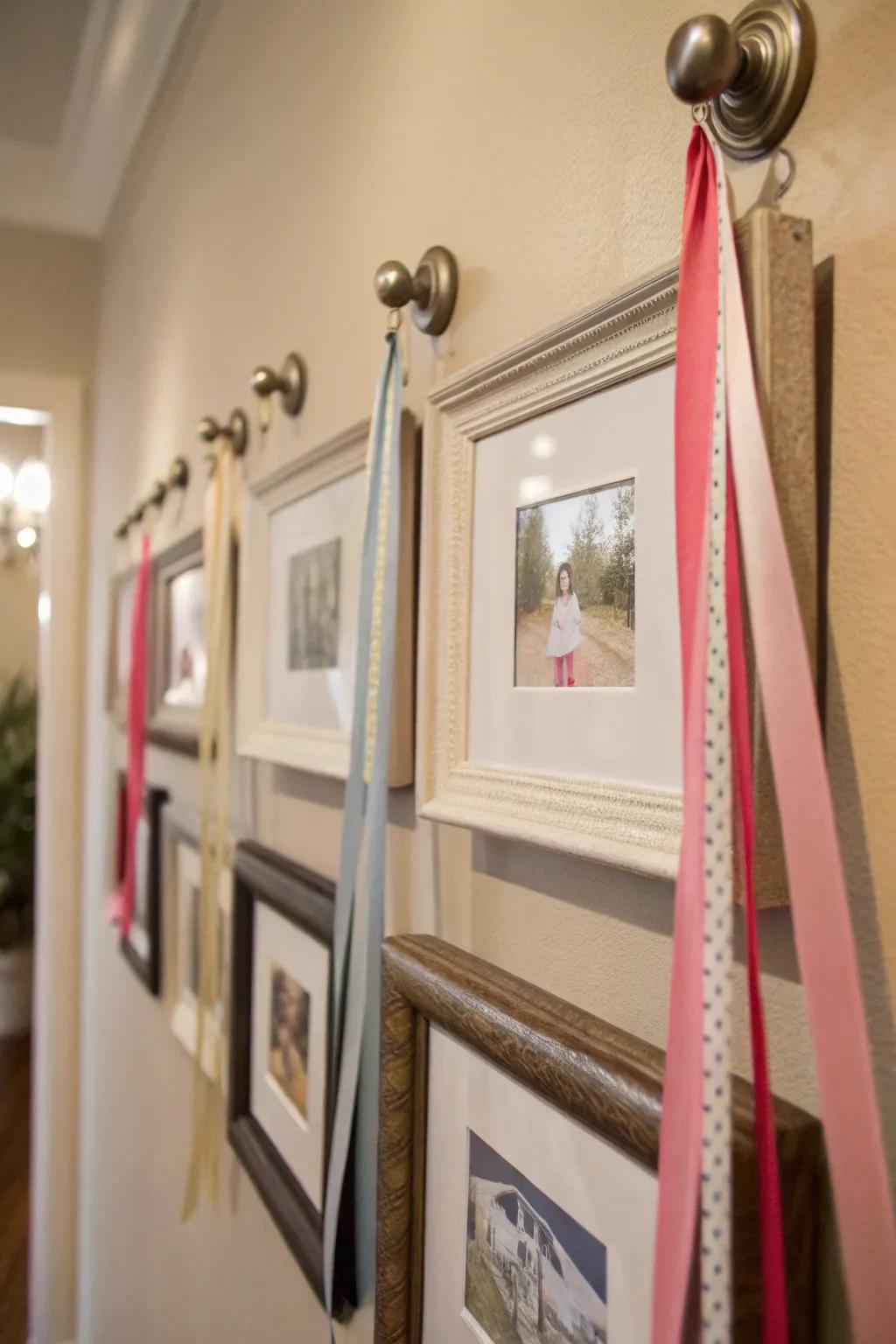 An intriguing wall display with frames hung from knobs using ribbons.