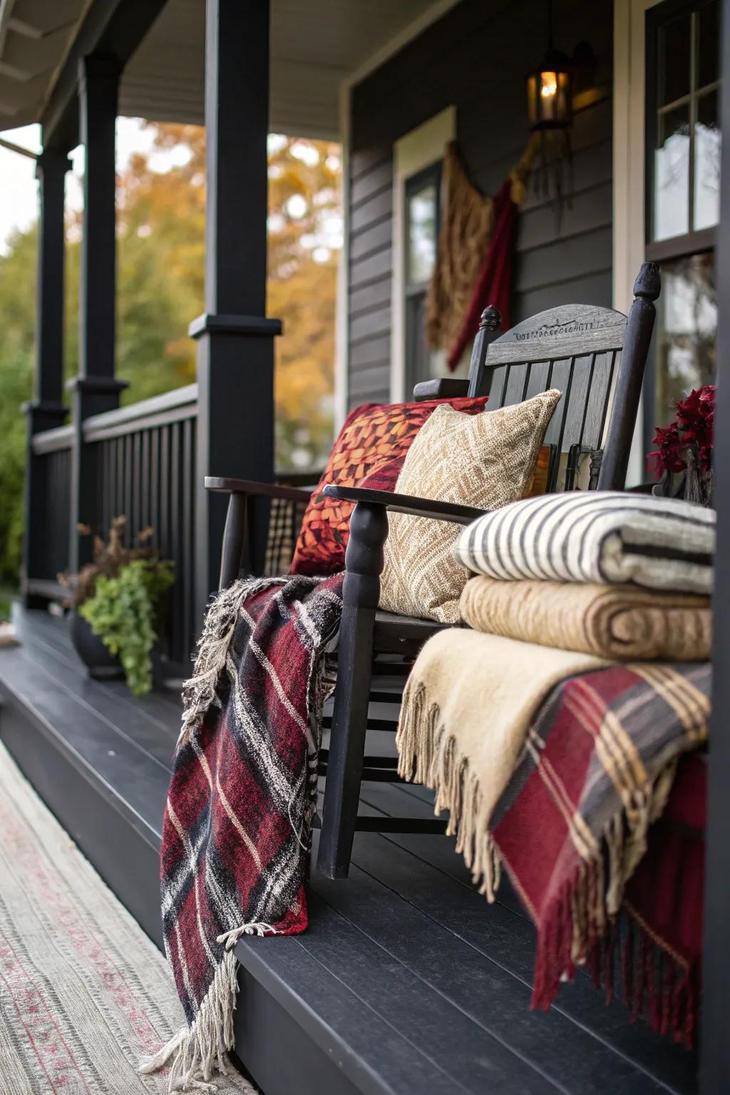 Layered textiles, such as throws and pillows, adding depth to a dark porch.