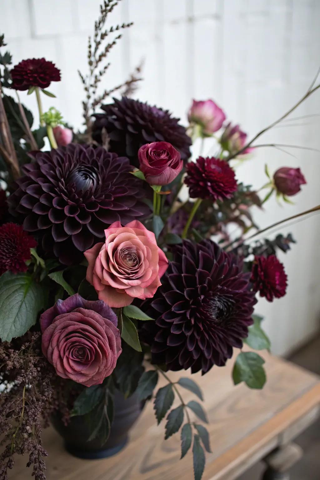 An atmospheric bouquet showcasing ebony dahlias and plum roses.