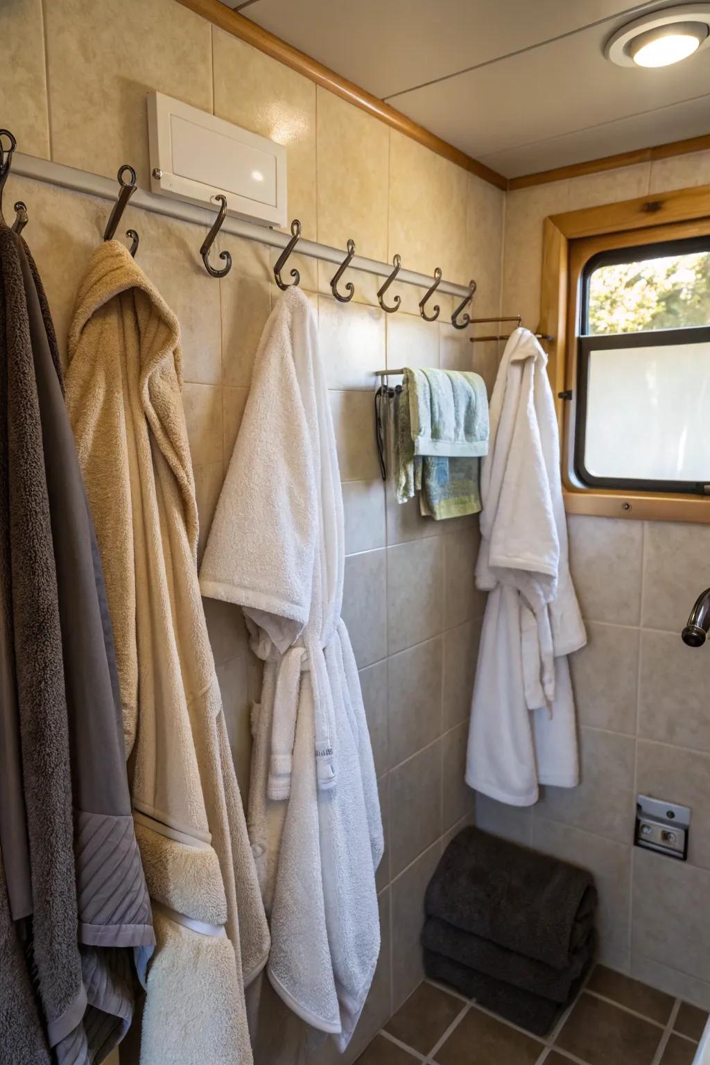 Hooks providing easy access to towels and robes in a camper bathroom.