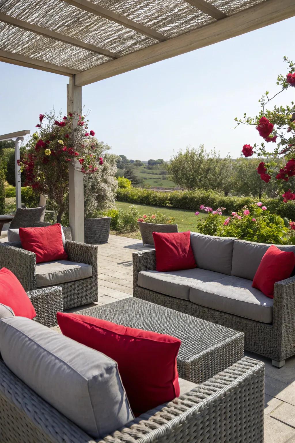 An outdoor patio showcasing silver furniture and scarlet pillows.